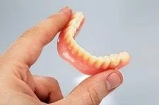 person holding dentures Littleton, CO general dentist