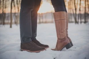 Man and Woman's Boots in the Snow