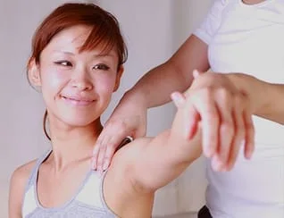 smiling lady with her arm being gently held up by another person 