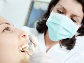 woman with mouth open getting dental exam by female dentist North York, ON