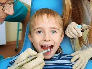 young blond boy with mouth open as North York dentist works on his teeth. Pediatric Dentistry North York, ON
