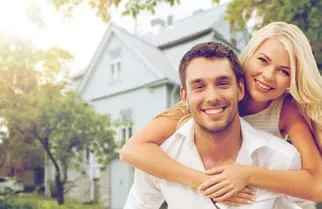 young couple in front of a home