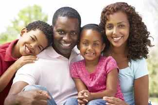 young black family smiling and posing outdoors, family dentistry in Austin, TX
