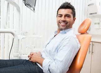 man smiling sitting in dentist chair, Phoenix, AZ cosmetic dentistry