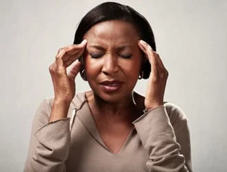 Woman with tension headache holds head