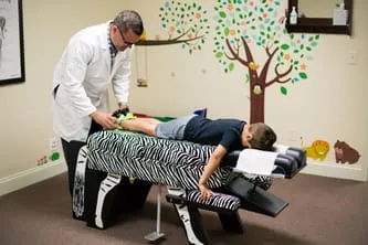 Doctor Adjusting Pediatric Patient