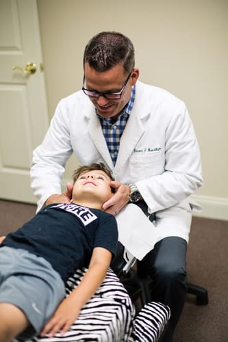Doctor Adjusting Pediatric Patient
