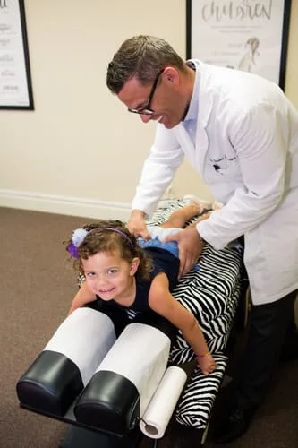 Doctor Adjusting Pediatric Patient