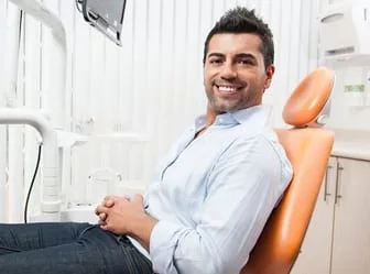 man sitting in dental exam room chair, smiling nice teeth, same day crowns Verona, PA dentist