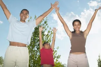 Three children with their arms above their heads. Two are teenages and one is much younger.