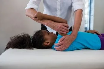 pediatric chiropractor care in kenosha doing spinal adjustment treatment on a kid