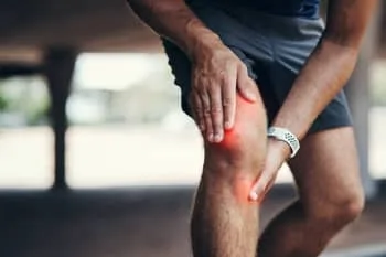 An athlete suffers from knee injury while doing some out door exercise