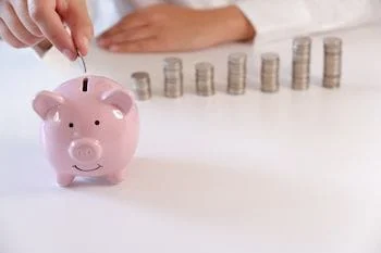piggy bank and coins that can be saved with using choosehealthy program insurance