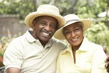 older black man and woman wearing hats, outside smiling, Implant Dentures Plantation, FL