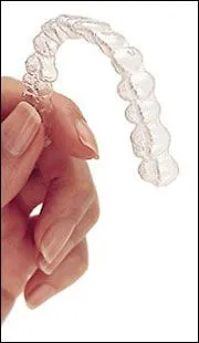hand holding Invisalign clear aligner