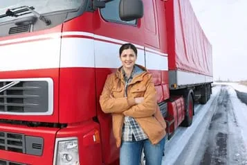 woman standing next to semi truck