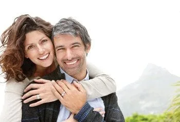 middle aged couple hugging outdoors smiling, dental implants Fairfax, VA and South Riding, VA