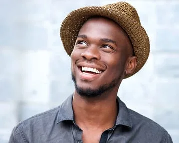young black man wearing hat looking up and smiling, nice teeth, dentist Royal Palm Beach, FL