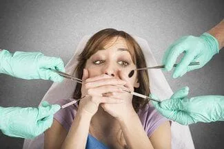 girl holding mouth closed near dental tools afraid of dentist, sedation dentistry Wallace, NC