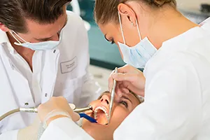 dentist and assistant doing dental work on female patient, oral surgery Beverly Hills, MI, oral surgeon