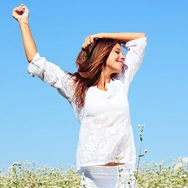 A smiling woman raising her right arm