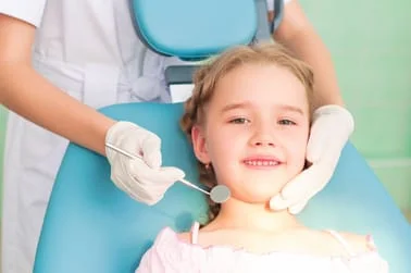 young blond girl sitting in dental chair, children's dentistry Durham, NC 