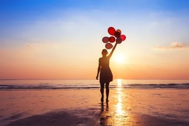 lady on beach with balloons