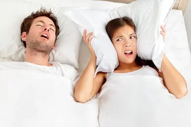 man snoring next to woman covering ears with pillow, San Jose, CA sleep apnea oral appliances therapy