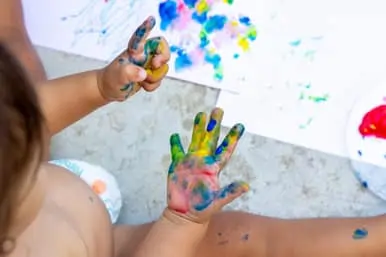 parent and child with paint on hands