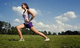 A_young_woman_stretching_outdoors_before_exercising.jpg