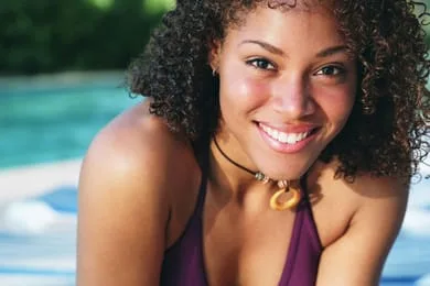 young black girl wearing swimsuit by pool, smiling nice teeth, dental crowns Bradenton, FL dentist