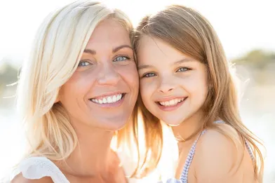 young mom holding child outdoors smiling, Old Bridge, NJ family dentist