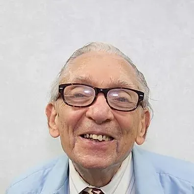 A man with glasses and a suit on.