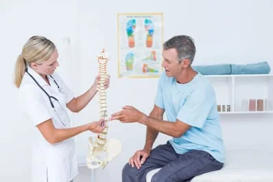 doctor and patient looking at example of a spine