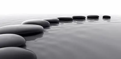 large stones creating a curved line in a lake