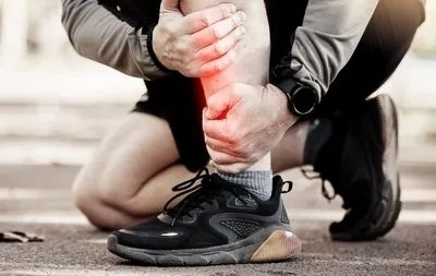 Man-suffering-in-foot-pain-with-black-sneaker-outdoor.
