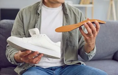 Male preparing to place custom orthotic in shoe