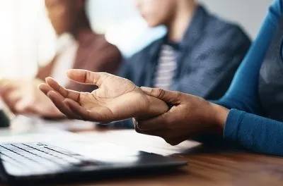 Illustratio of carpal tunnel syndrome on a person using a laptop