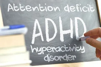 ADHD written on blackboard with books.