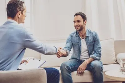 Man participating in acceptance and commitment therapy session with a mental health professional.