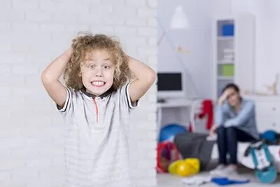 Young boy smiling on camera annyed his mother