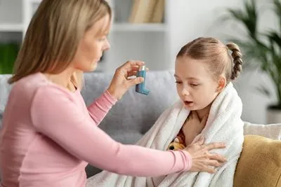 Young girl with asthma with mother beside her.