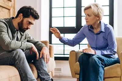 Therapist supporting a man struggling with anger in a counseling environment.