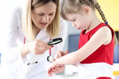 Child receiving dermatology checkup from pediatric skin specialist
