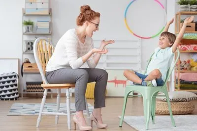 Therapist play with the young boy on playroom