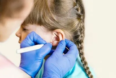 Pediatrician conducting a safe ear piercing procedure