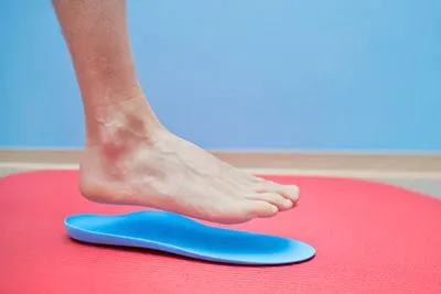 Individual testing new orthotic inserts before placing them in shoes
