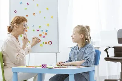 Child receiving speech therapy as part of pediatric rehabilitation