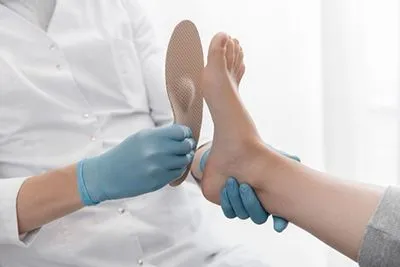 Doctor checking the size of custom orthotics