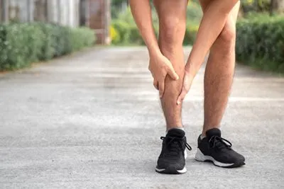 Male runner holding leg in pain from shin splints